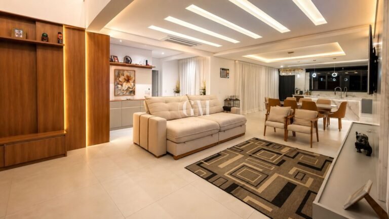 Sala de estar ampla com painel de madeira integrada à sala de jantar da casa no Bosque do Horto