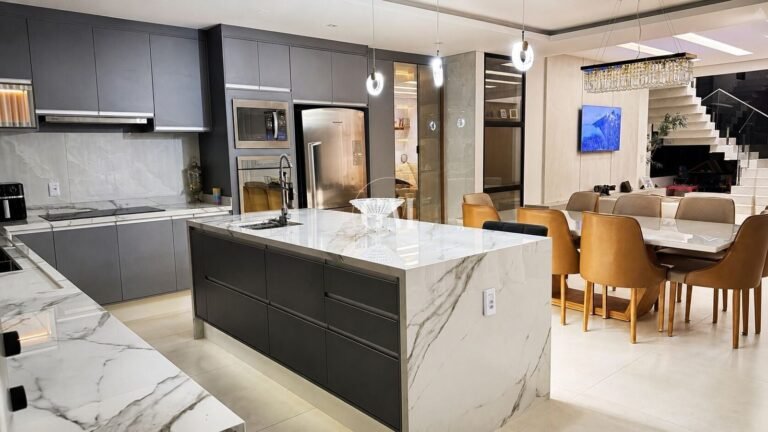 Cozinha gourmet com ilha em mármore integrada à sala de jantar